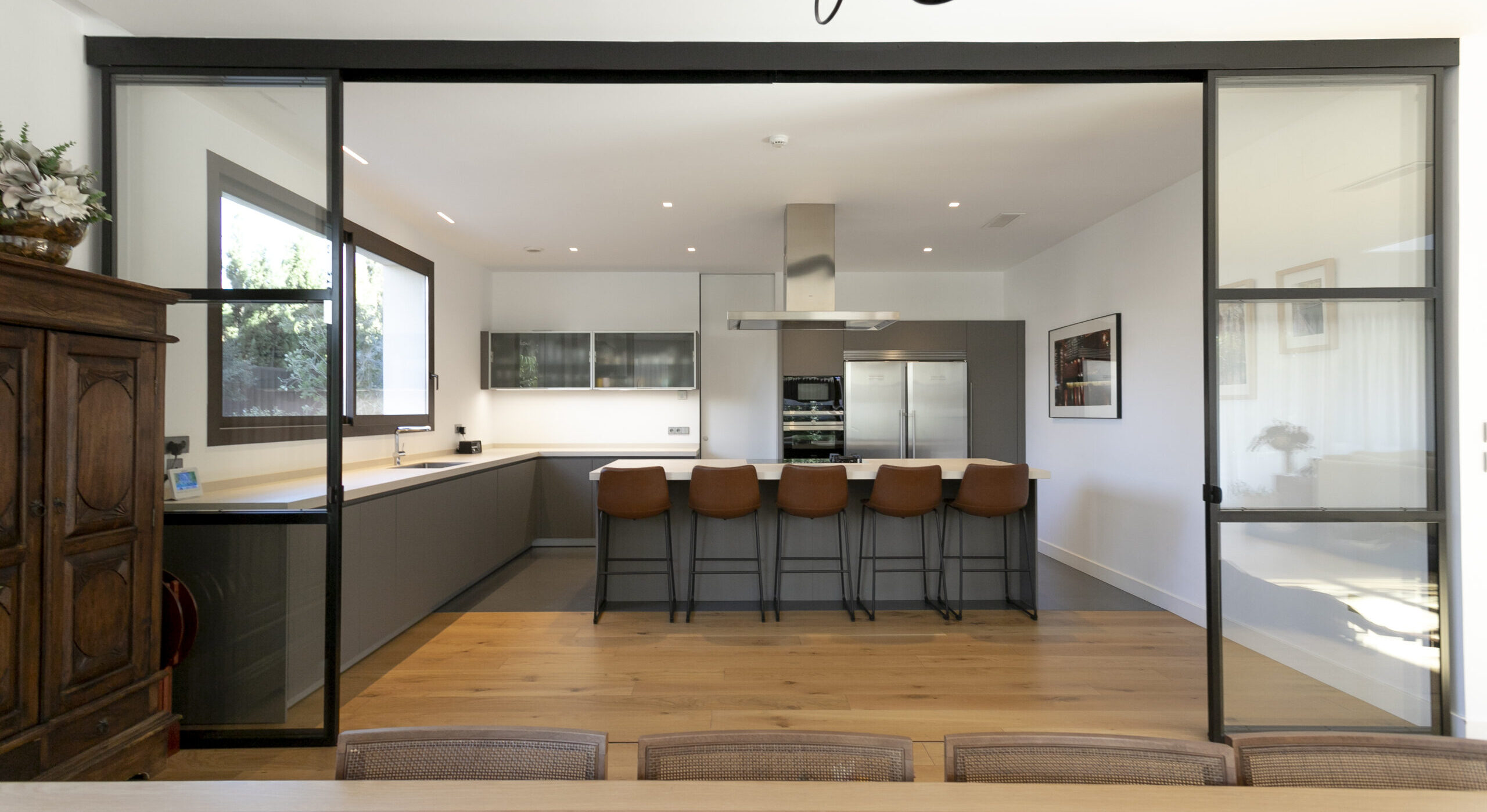 Una cocina semiabierta al salón con puertas correderas, amplia y elegante